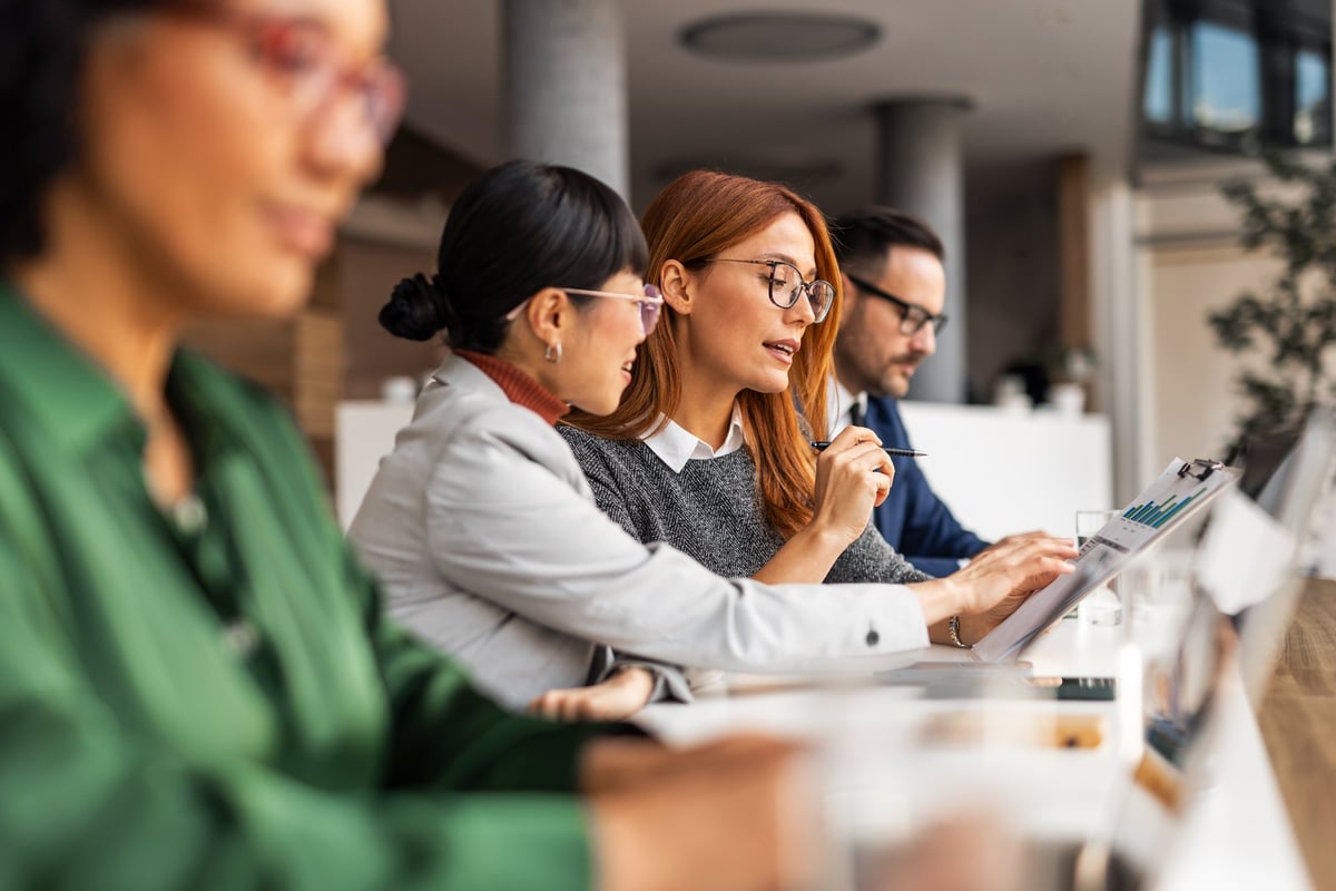 A family office team collaborating over documents around a meeting table