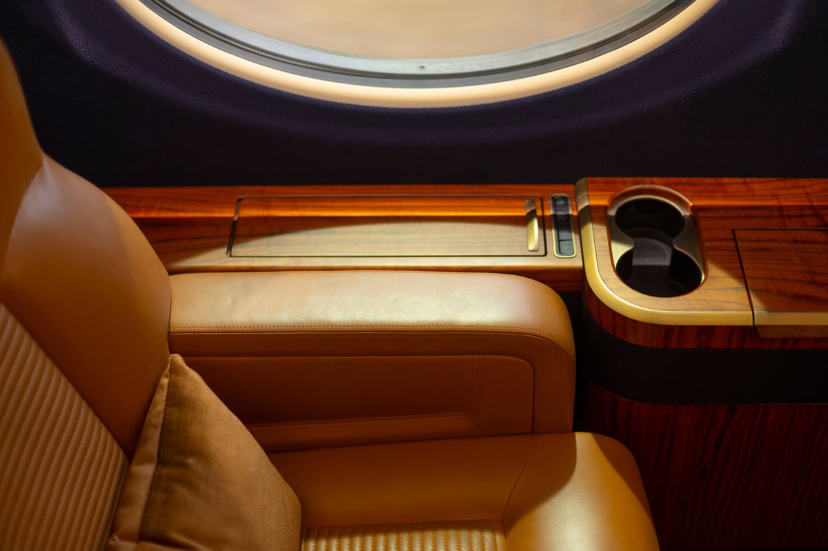 Opulent private jet cabin interior with warm low light and pristine leather seating