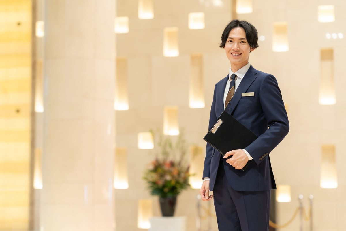 A hotel concierge attending to a guest — the discreet, anticipatory service standard behind every JetBrands itinerary