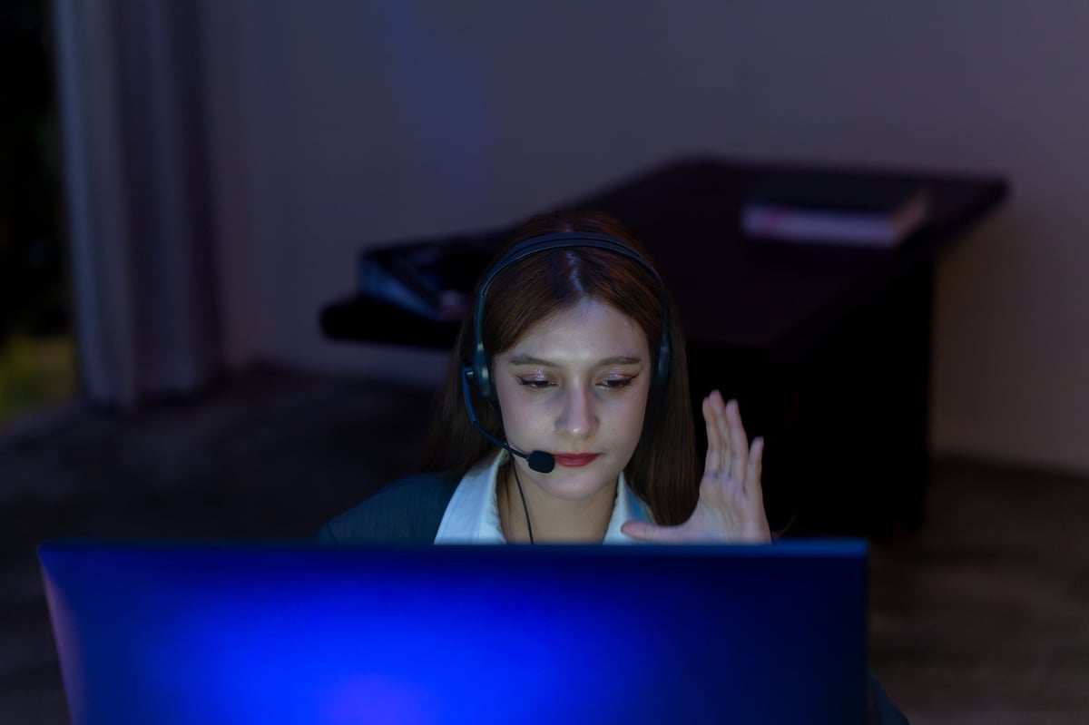 Professional concierge on a call late in the evening, workspace in low light